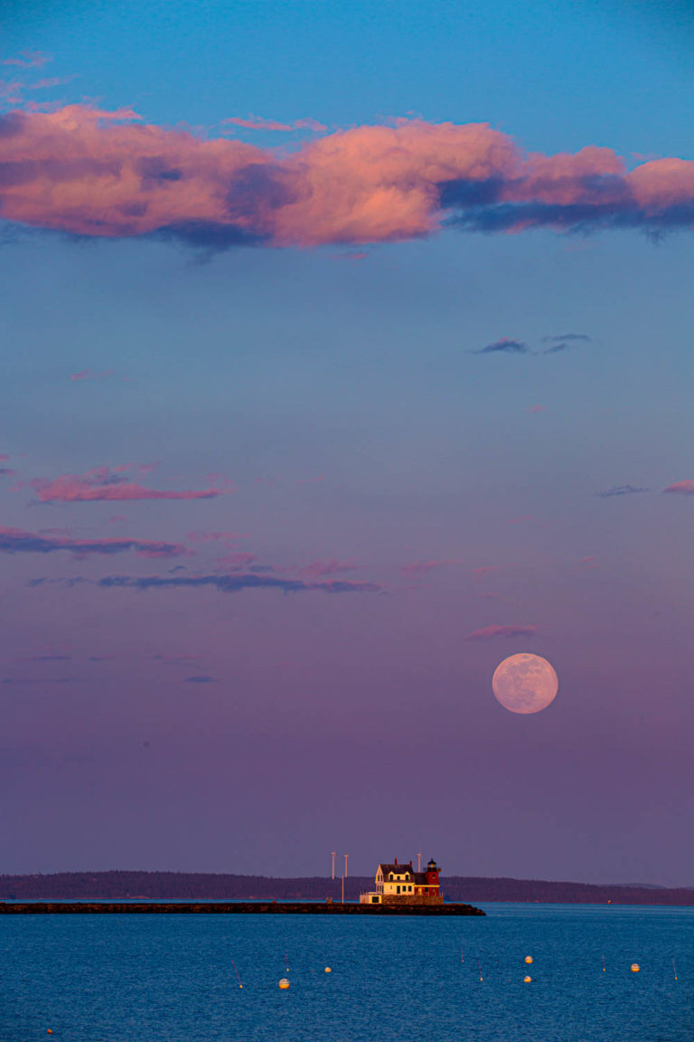 Full moon rises over Rockland Breakwater Lighthouse.