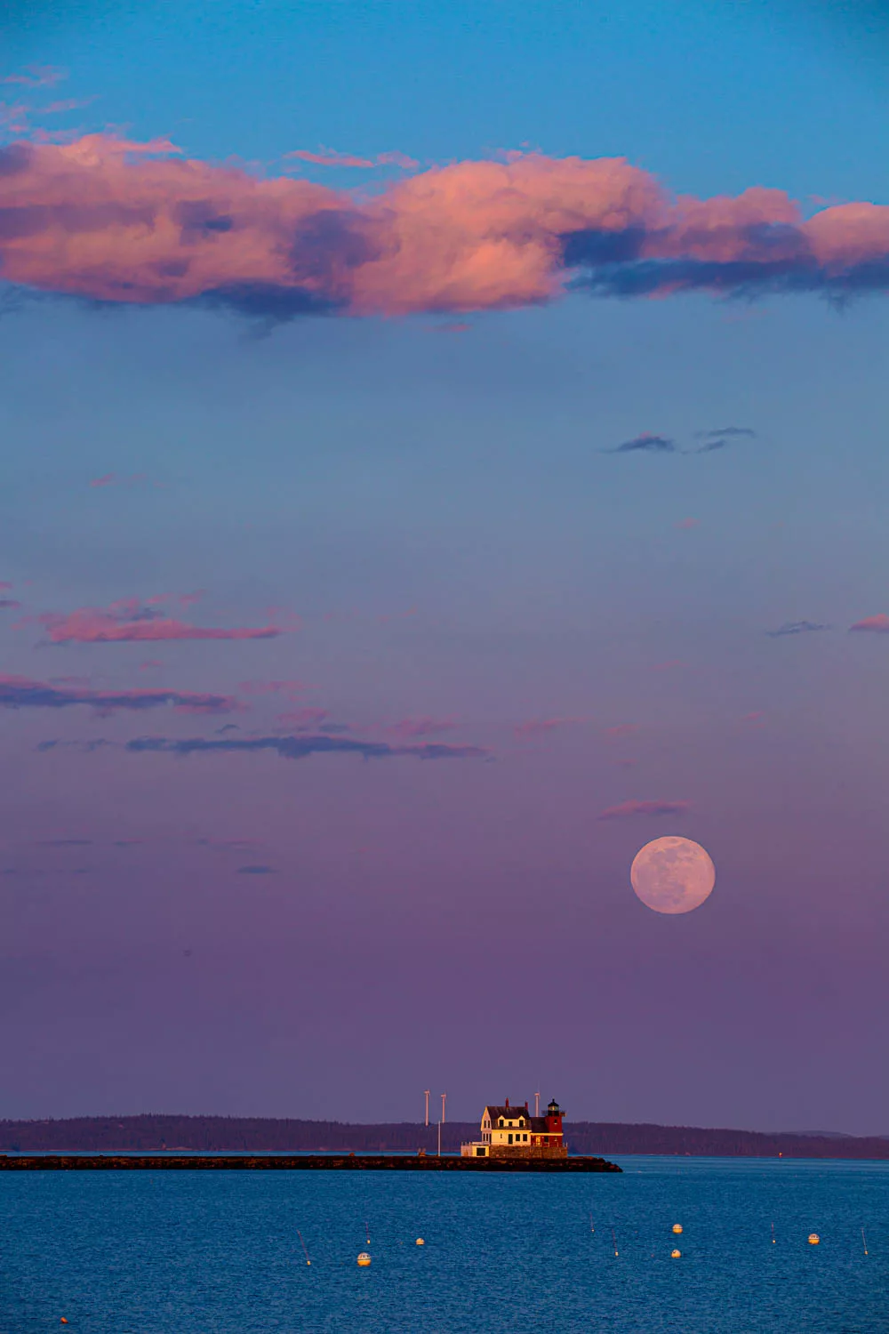 Full moon rises over Rockland Breakwater Lighthouse.